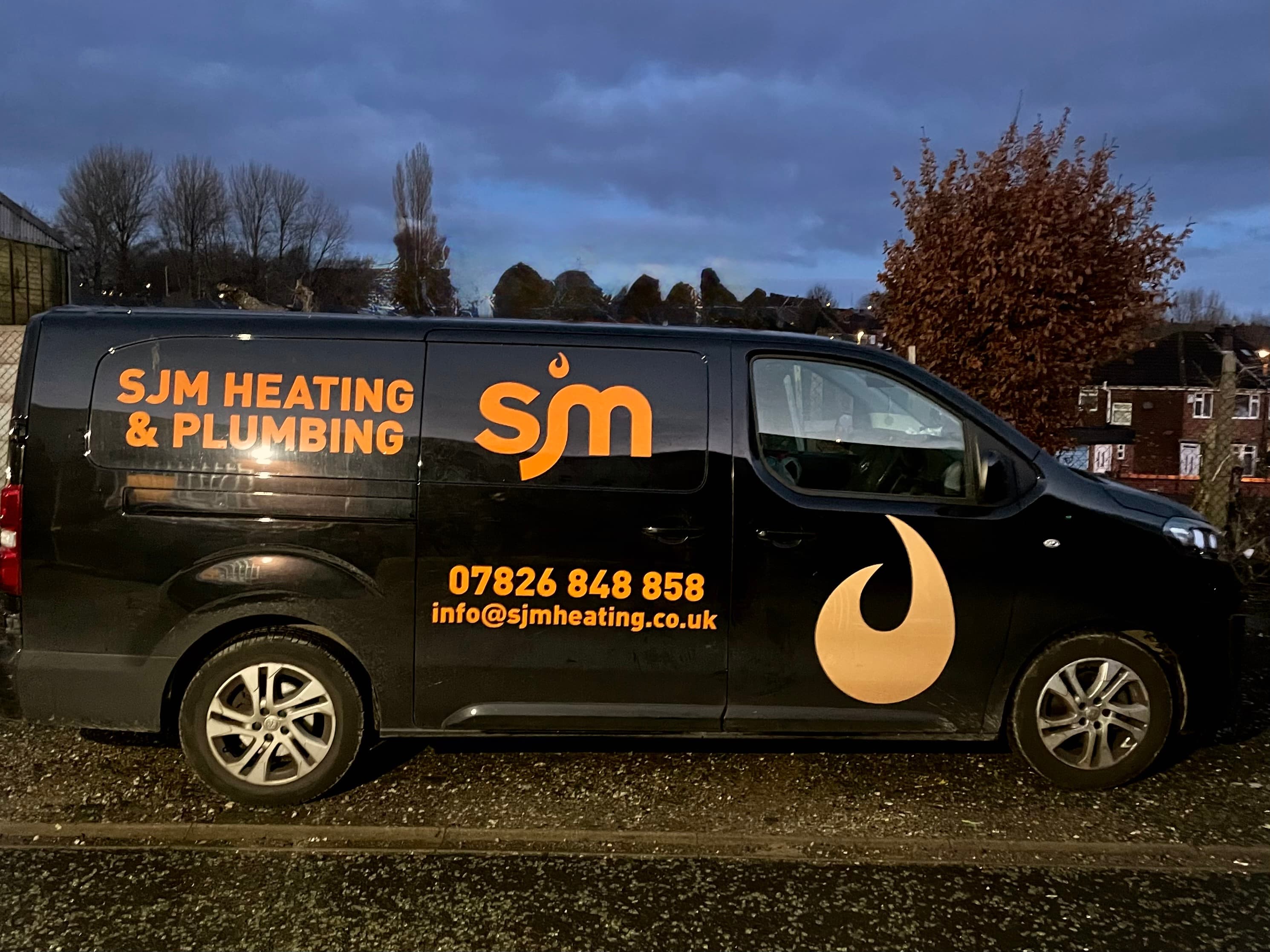 SJM Heating van parked outside a project
